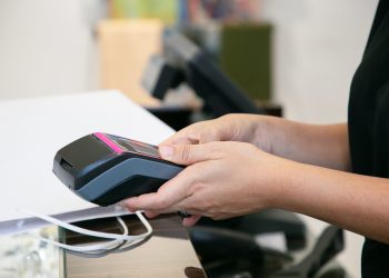 Cashier or seller operating payment process Cashier or seller operating payment process with pos terminal and credit card. Cropped shot, closeup of hands. Shopping or purchase concept